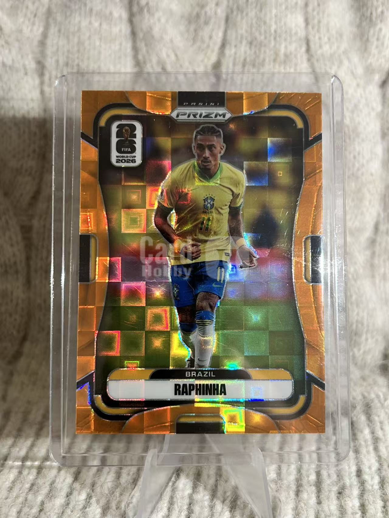 2026 Panini Prizm World Cup Raphinha 拉菲尼亚,橙棋盘折,136/215 编。巴西边锋,赛场奔跑选图,棋盘格限量折射